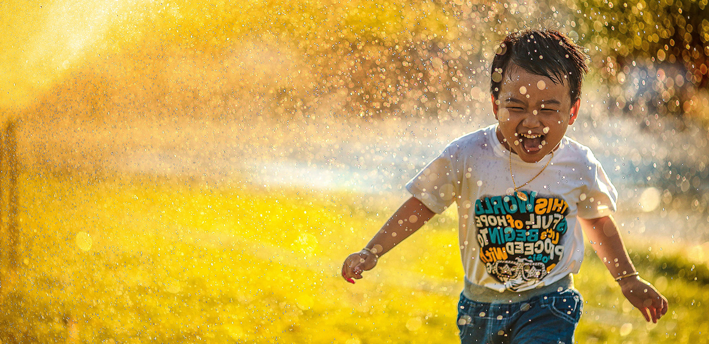 Child Playing in Sprinkler